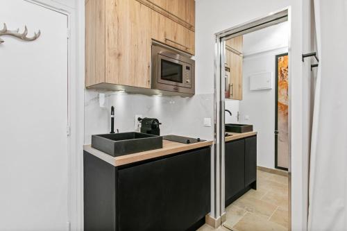 une cuisine avec un évier et un micro-ondes dans l'établissement Morea Port nature vue mer, au Cap d'Agde