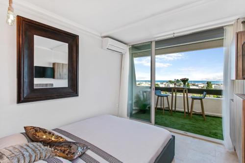 une chambre avec un lit et une grande fenêtre dans l'établissement Morea Port nature vue mer, au Cap d'Agde