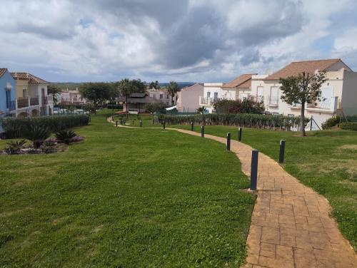 a walkway in a park with houses in the background at Vista Hermosa in Ayamonte