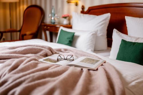 a pair of glasses and a book on a bed at Alt Lohbrügger Hof in Hamburg