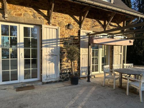a patio with a table and an umbrella next to a building at Au repos du Vicomte in Cockaifagne