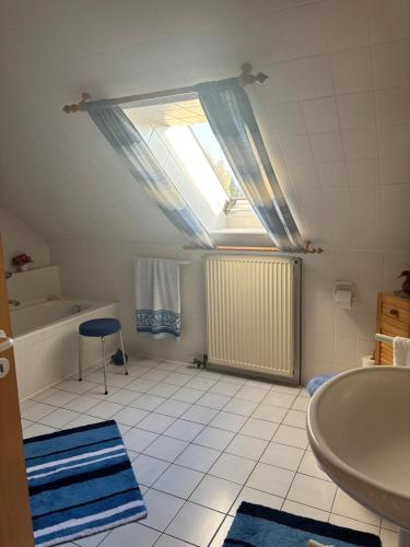 a bathroom with a sink and a tub and a window at Beautiful apartment Osloß in Osloß