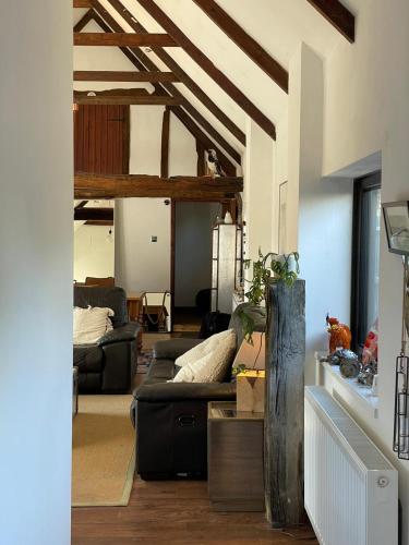 a living room with a couch and a table at Milk Barn - Rustic farm stay in Great Chart