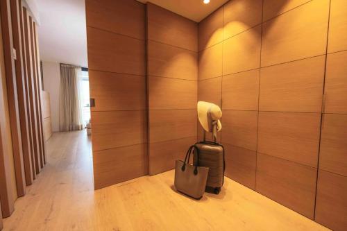 a room with a bag and a wall with wood at Hotel Port Salins by Pierre & Vacances in Empuriabrava