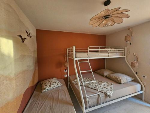 Ce lit superposé se trouve dans un dortoir doté d'un plafond. dans l'établissement Bel appartement avec grande terasse sur le vieux port, au Cap d'Agde
