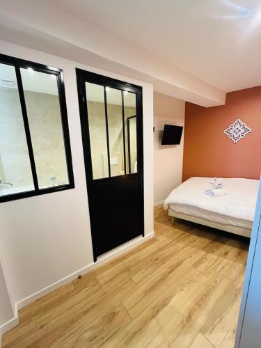 a room with a bed and a black door at Abelia YourHostHelper in Falaise