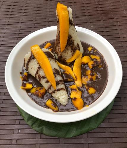 a white bowl of food with chocolate and mango slices at Forest Camp in Valencia