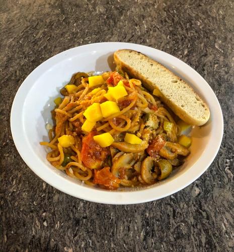 a bowl of spaghetti with a slice of bread at Forest Camp in Valencia