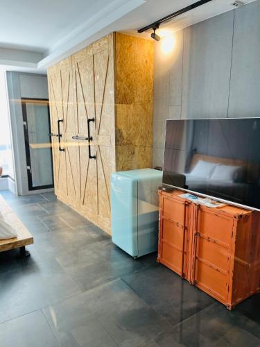 a kitchen with wooden cabinets and a large refrigerator at 阡陌-頂加民宿 in Tainan