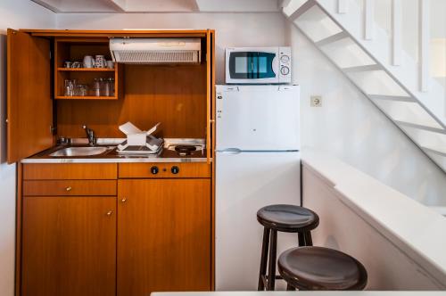 a small kitchen with a refrigerator and a sink at Seaside Apartments in Adamantas