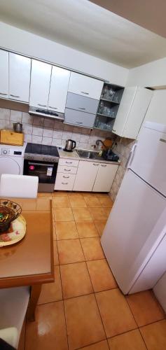 a kitchen with white cabinets and a table in it at Aleks 4 in Skopje