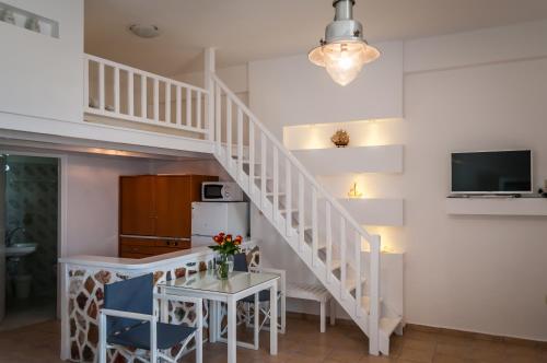 a white staircase in a living room with a table at Seaside Apartments in Adamantas