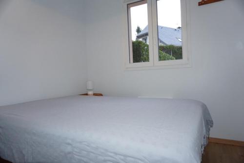 un lit blanc dans une chambre avec une fenêtre dans l'établissement Clos saint michel, à Luz-Saint-Sauveur