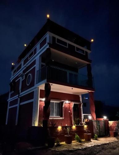 a tall building with lights on it at night at Earthern Brick home at Nandi in Nandi