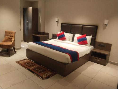 a bedroom with a large bed and a chair at VIORAY INN in Deoghar