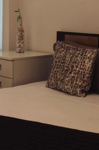 a bed with a pillow and a vase on it at VILLA CALATHEA Varkala in Varkala