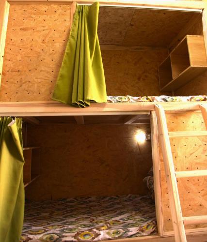two bunk beds with green curtains in a room at 喀什故人归国际青年旅舍 Kashgar Returning Friends International Youth Hostel in Kashgar