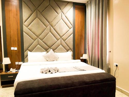a bedroom with a large bed with a large headboard at City King Hotel in Kano
