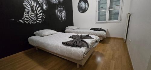 deux lits dans une chambre avec de l'art en noir et blanc sur le mur dans l'établissement Disneyland smart appartement, à Serris