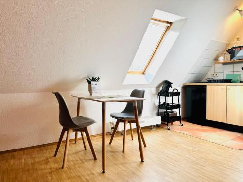 a dining room with a table and two chairs at Galerie-Dachstudio- Ruhig & kompakt-Waschmaschine- WLAN- Parkplatz in Wolfsburg