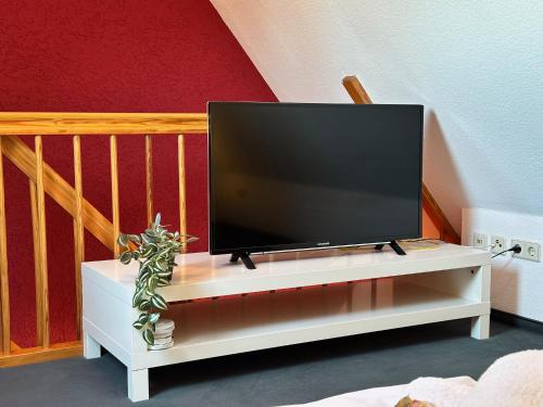 a flat screen tv sitting on a white entertainment center at Galerie-Dachstudio- Ruhig & kompakt-Waschmaschine- WLAN- Parkplatz in Wolfsburg