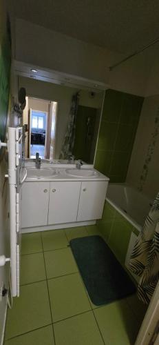 une salle de bain avec deux lavabos et une baignoire dans l'établissement Disneyland smart appartement, à Serris