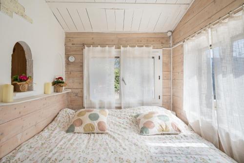 a bedroom with a bed with pillows and a window at La Bergerie des Cimes in Lantosque