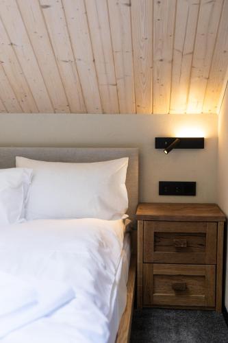 a bedroom with a white bed and a wooden ceiling at Moho Будинки для відпочинку in Bukovel