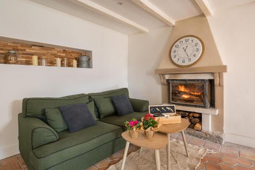 a living room with a green couch and a fireplace at La Bergerie des Cimes in Lantosque