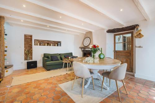 a living room with a table and a green couch at La Bergerie des Cimes in Lantosque