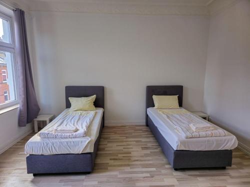 due letti uno accanto all'altro in una stanza di Großzügiges Apartment mit Balkon und 3 Schlafzimmern a Neumünster