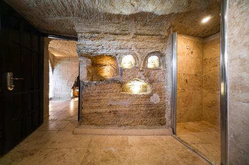un couloir avec un mur de briques avec un lustre dans l'établissement Azalea Terrace Cave Hotel, à Gorëme