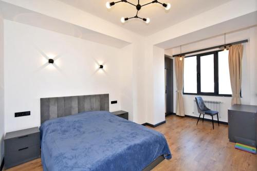 a bedroom with a bed and a desk and a chair at Komitas Comfort and Charm in Yerevan