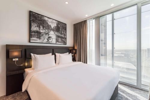 a bedroom with a large bed and a large window at Radisson Hotel & Suites Amsterdam South in Amstelveen