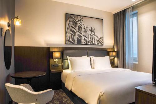 a hotel room with a bed and a chair at Radisson Hotel & Suites Amsterdam South in Amstelveen