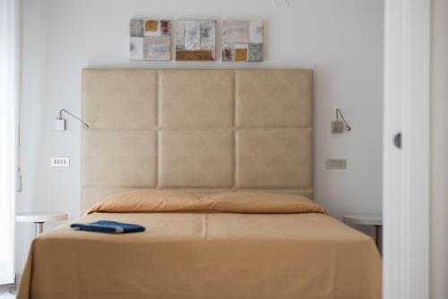 a bed with a headboard in a bedroom at Hotel Gabriella in Rimini