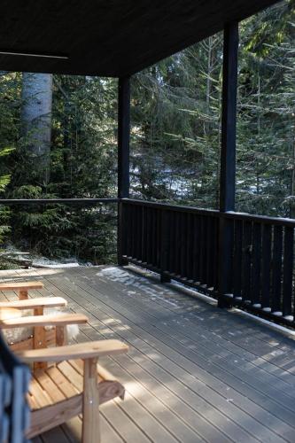 a screened in porch with benches on a deck at Moho Будинки для відпочинку in Bukovel