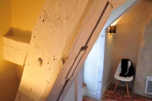 a wooden door in a room with a chair at Les Glycines Vézelay in Vézelay