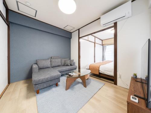 a living room with a couch and a bed at Shibuya Area ,Ebisu 3min walk,Harajuku 2min,Queen Bed,Switch,Free Wi-Fi , PocketWi-Fi in Tokyo
