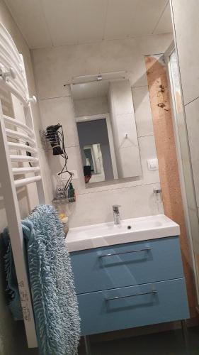 une salle de bain avec un lavabo et un miroir dans l'établissement Appartement Les Galées avec terrasse à 100m Plage des Mouettes, à Saint-Hilaire-de-Riez