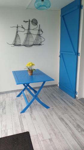 une table bleue dans une pièce avec une porte bleue dans l'établissement Appartement Les Galées avec terrasse à 100m Plage des Mouettes, à Saint-Hilaire-de-Riez