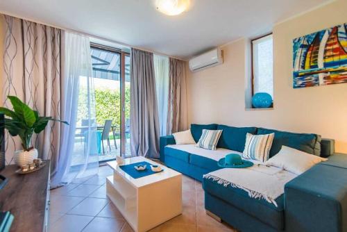 a living room with a blue couch and a window at Villa Maklavun by Kompas Villas in Kanfanar