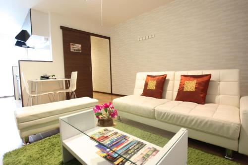 a living room with a white couch and a table at Forest Terrace Tenjinminami in Fukuoka