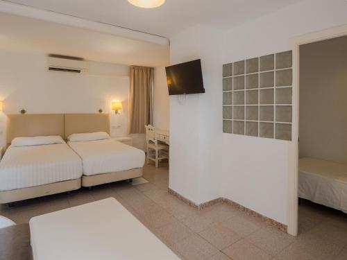 a hotel room with two beds and a tv at Sun Club El Dorado - All Inclusive in Llucmajor