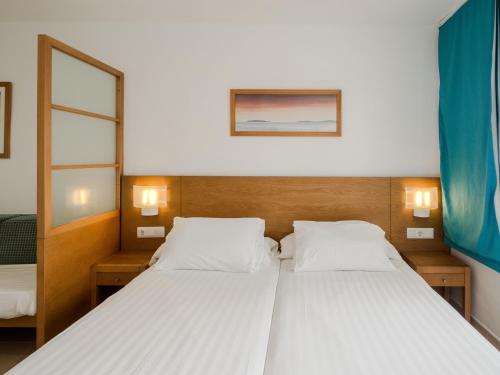 a bedroom with a large bed with two white pillows at Sun Club El Dorado - All Inclusive in Llucmajor