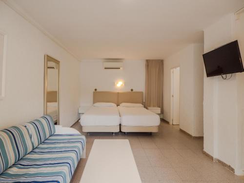 a living room with two beds and a couch at Sun Club El Dorado - All Inclusive in Llucmajor