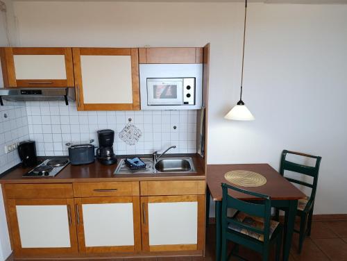 una piccola cucina con un lavello e un tavolo di Haus Meeresblick WM510 a Kühlungsborn