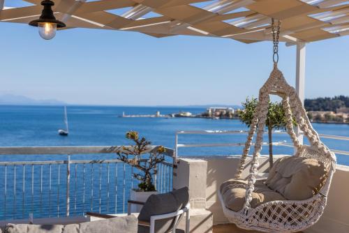 a swinging chair on a balcony overlooking the water at Unique apartment in Corfu Town