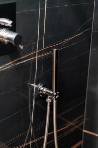 a black tiled wall with a piping in a bathroom at DimorAmare in Bari
