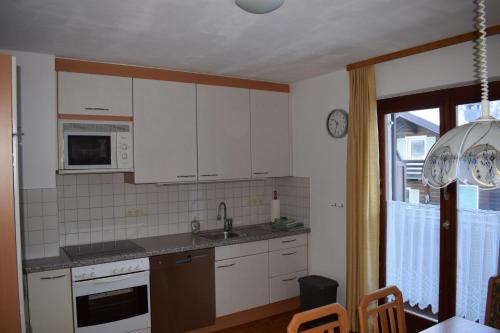 a kitchen with white cabinets and a sink at Ferienhaus Gioia in Schruns-Tschagguns